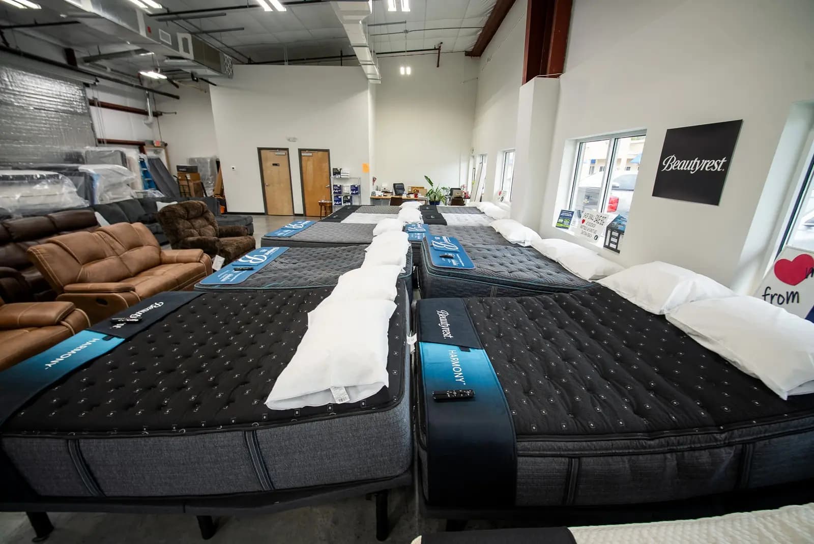 Quilted mattresses lined up at the BoxDrop Daytona Beach showroom
